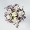 From the first glance, this Southfields bouquet exudes an air of peaceful refinement, thoughtfully composed to enchant and comfort. Six creamy white roses rest at the centre, their petals gathered in tight, symmetrical spirals that speak of patience and loving care. Around them, a soft haze of lilac and pale lavender statice forms an airy, textured border, the tiny blossoms merging in a gentle ribbon of colour that enhances the crisp white roses. The visual effect echoes the gentle blush of Southfields gardens in spring, or the subtle hues rising above the All England Club at dawn. The bouquet is round and lush, every stem intentionally placed so that no single element overpowers, and the purity of the palette is allowed to shine. Set on a clean, off-white or pale grey surface, the arrangement is awash in even daylight, illuminating the natural beauty and delicate details of each flower without a single harsh line. More than a decorative piece, this bouquet could mark a meaningful pause-a new chapter, a heartfelt tribute, or a graceful addition to a family gathering off Replingham Road. It is a tactile reminder of Southfields' dedication to quality, artistry, and the subtle joy of sharing beauty in life's tender moments.
