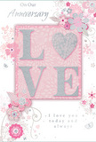 This anniversary card appears as a tender celebration of enduring romance, its design as gentle and composed as a pastel arrangement delivered to a doorstep in Southfields. At the very centre, the word LOVE stands in raised, softly sparkling letters, with the letter O transformed into a silver, textured heart that glimmers like a small piece of jewellery. The glitter is subtle, in tones of blush pink and pale pearl, catching the light with each movement of the card. Around this central motif, delicate blooms in blush and mauve unfurl across the front, their shapes soft and almost watercolour-like, with fine lines defining petals and slender stems. Small flourishes-swirling vines, scattered petals, and discreet butterfly silhouettes-float among the flowers, adding a sense of gentle motion and playful elegance, reminiscent of petals drifting across the grass in King George's Park. The backdrop is a smooth, pastel pink, quietly supporting the more intricate elements without distraction. Scripted in understated, flowing type, the phrases On Our Anniversary and I love you today and always appear, their simplicity heightening their emotional weight. Viewed as a whole, the card feels like a paper echo of an anniversary bouquet: refined, heartfelt, and intentionally composed. It captures the intimacy of shared memories and the promise of many more years together, the same way a thoughtfully chosen arrangement from Flower Delivery Southfields might arrive with soft petals, fresh fragrance, and a sense of occasion that lingers long after the day has passed.